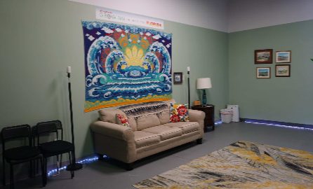 The studio room: a large mandala tapestry above the couch, with blue light along the skirting